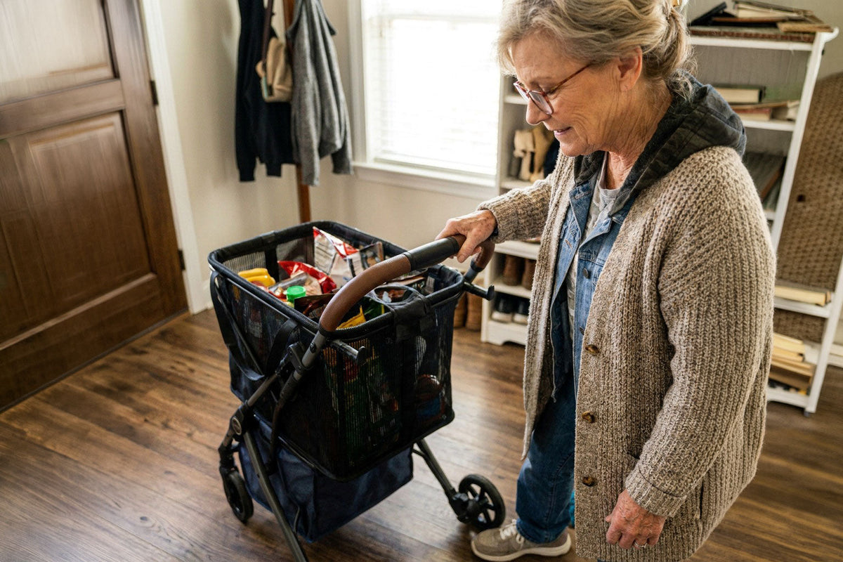 Vrouw naast een boodschappenwagen met levensmiddelen in een woning.