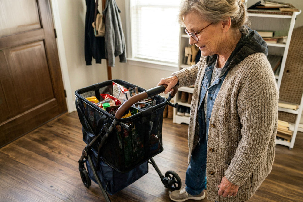 Femme près d’un chariot contenant des provisions à l’intérieur d’un logement.