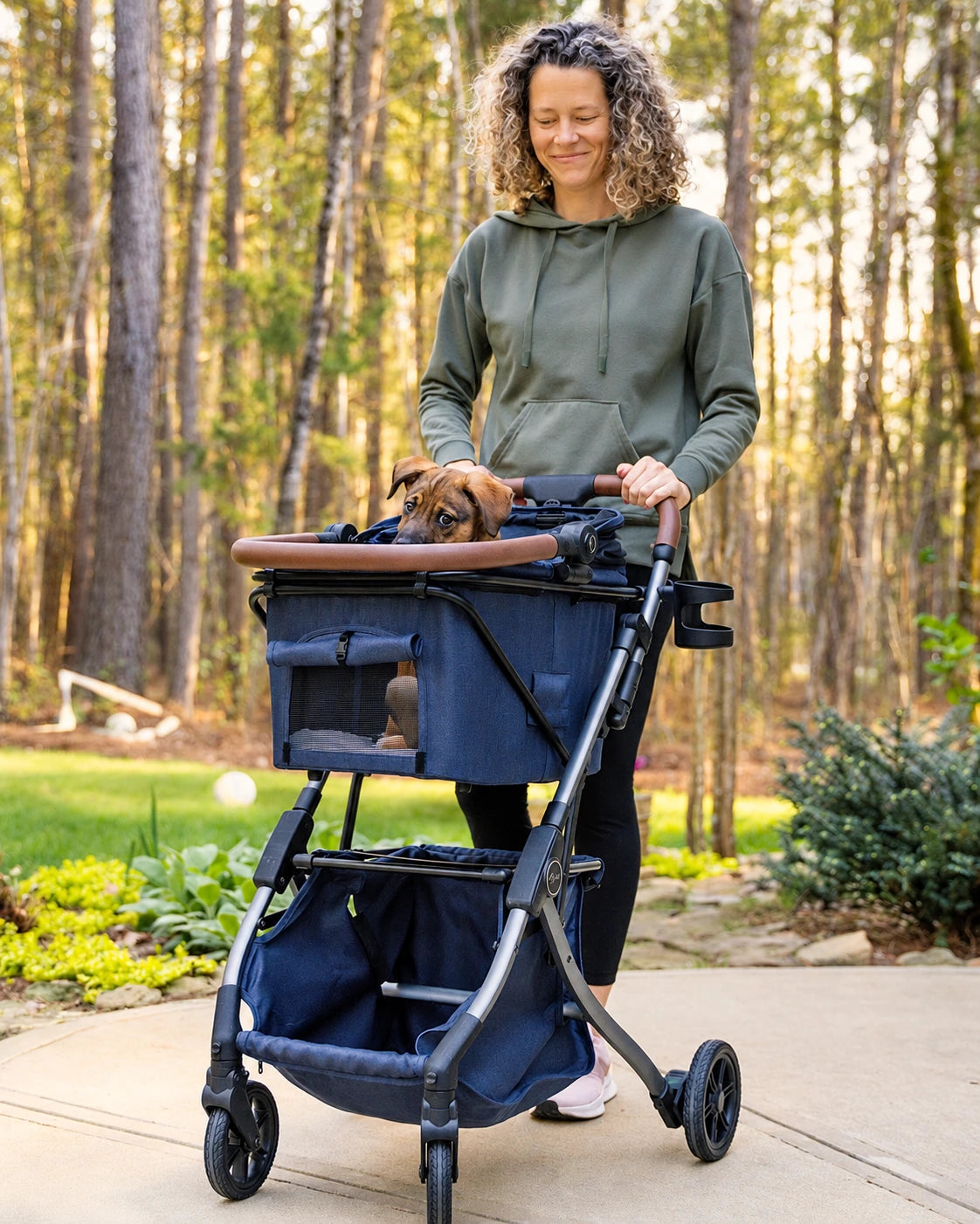Femme marchant avec un chariot Strolee et un chien dans le Pet Bassinet, coloris Blue.