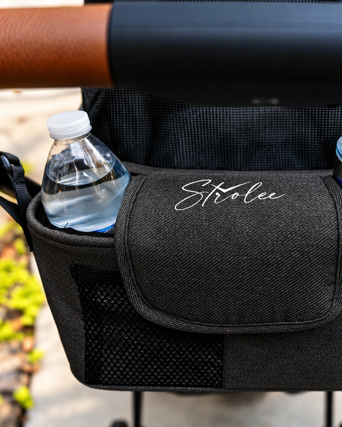 Bouteille d’eau dans la poche en maille d’un Personal Organizer, coloris Black, sous la poignée du chariot.
